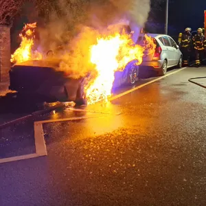 Feuerwehr steht neben brennendem BMW Roadster