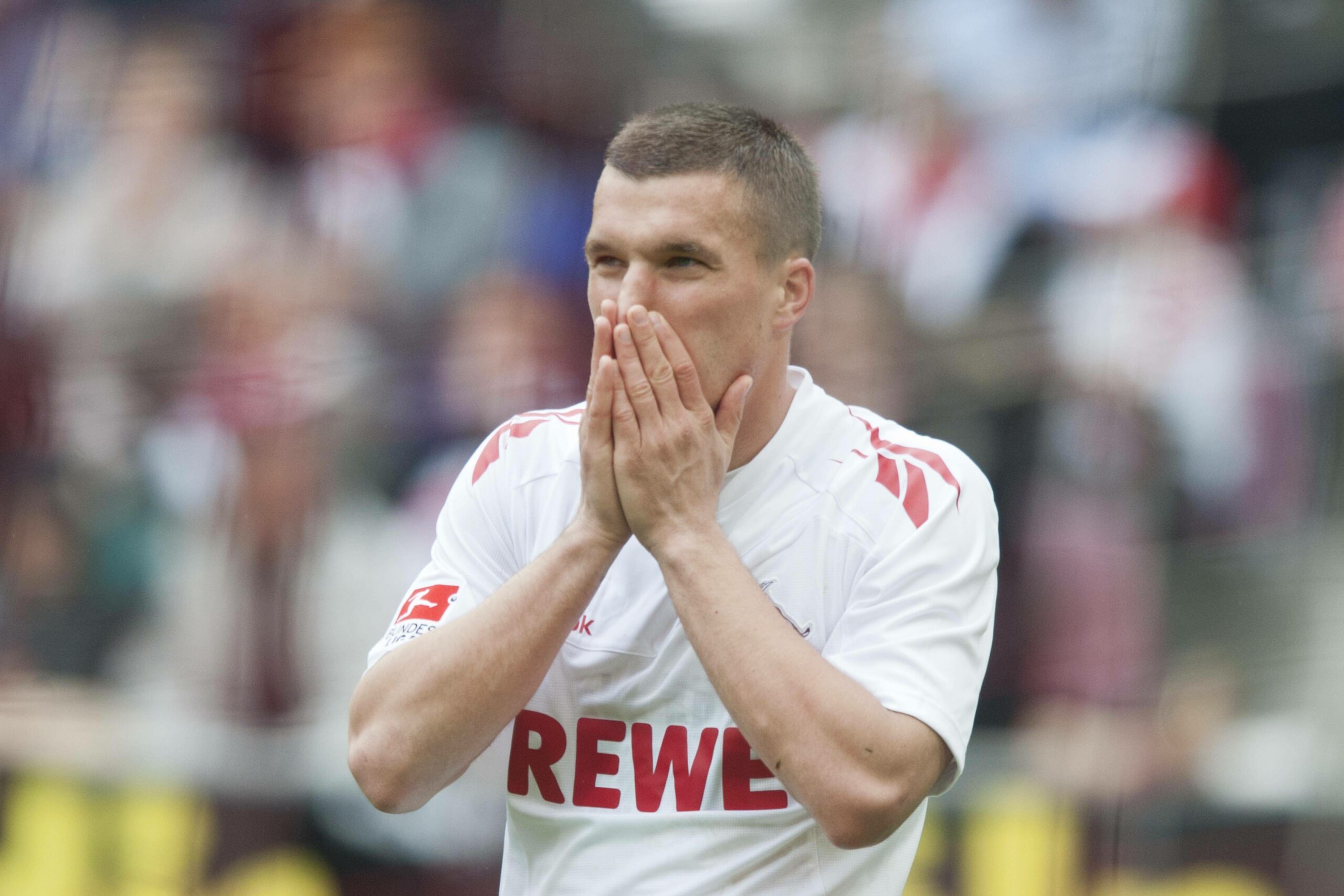 Lukas Podolski mit gefalteten Händen vor seinem Gesicht
