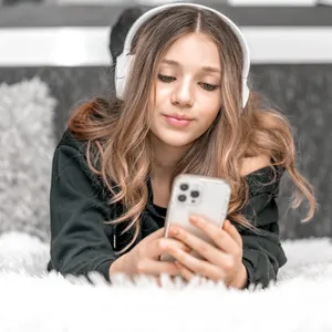 Ein Mädchen schaut auf ihr Smartphone. Ein Hamburger Verein setzt sich dafür ein, dass Kinder erst mit 14 Jahren ein eigenes Handy bekommen.
