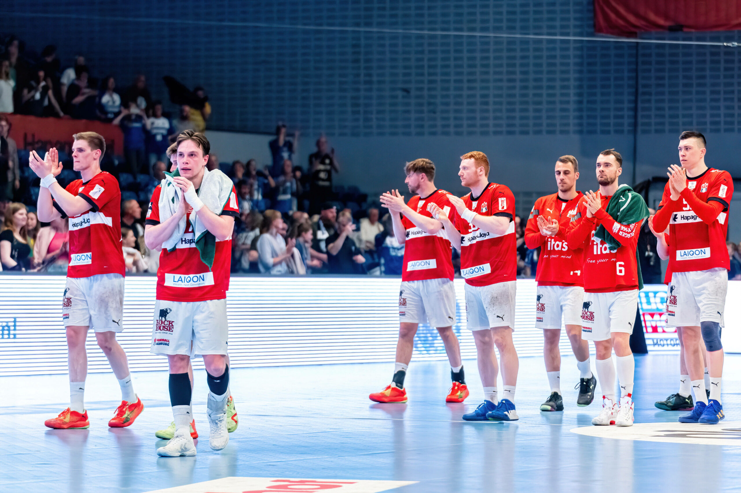Die Spieler des HSV Handball applaudieren ihren Fans nach Abpfiff.