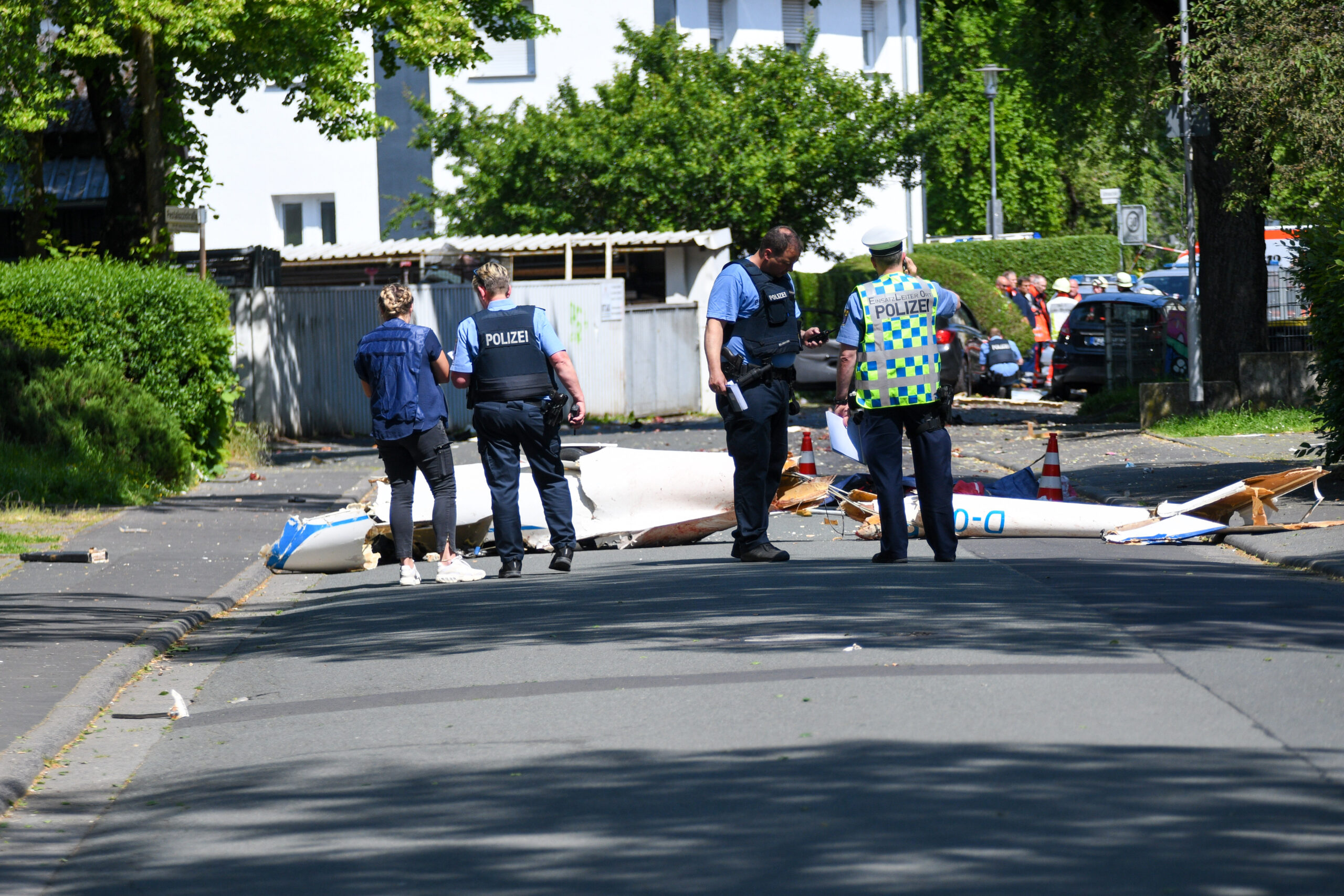 Trümmer liegen auf der Straße nach dem Absturz eines Leichtflugzeugs im Stadtgebiet von Wetzlar.