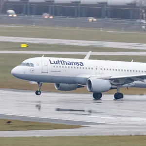 Ein Airbus A320 der Fluggesellschaft Lufthansa landet auf dem nassen Rollfeld.