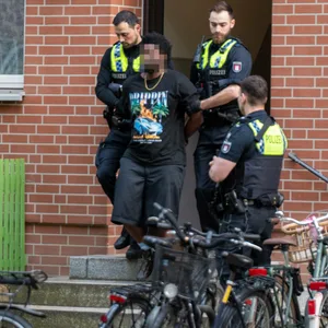 Die Polizisten führten einen Mann in Handschellen ab. Vorher sicherten Spezialkräfte den sogenannten Zugriff.