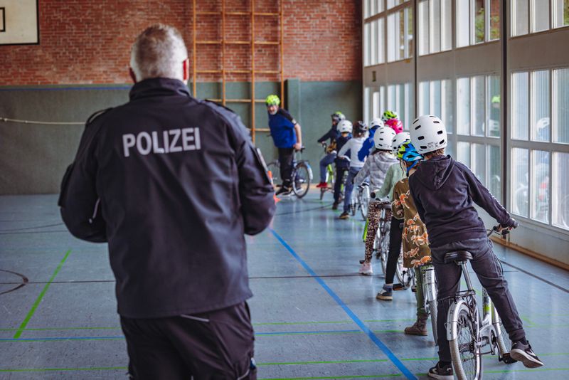 Polizeiverkehrslehrer Heino Krüger (links) und Jens Sulies (65, auf dem Fahrrad) üben mit dem Kindern den Schulterblick.