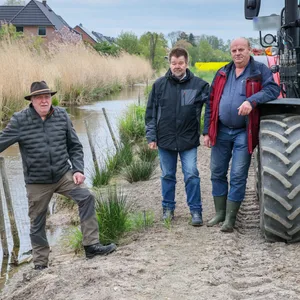 Jäger Gerald Eggers, Jörg Froh von der Bergedorfer CDU und Landwirt Heinz Wulff begutachten die Nutria-Schäden.