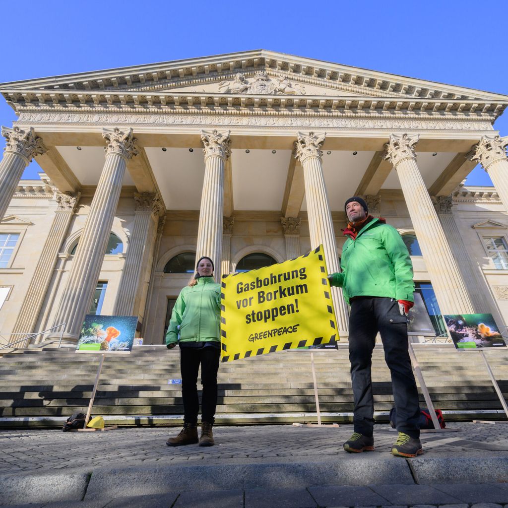Protestierende halten Banner mit Titel "Gasbohrung vor Borkum stoppen!" vor Landtagsgebäude