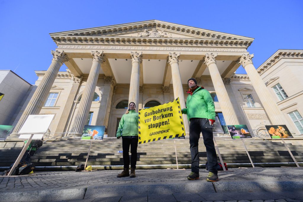 Protestierende halten Banner mit Titel "Gasbohrung vor Borkum stoppen!" vor Landtagsgebäude