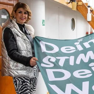 Sülmez Çolak (Grüne, l), Vizepräsidentin der Bremischen Bürgerschaft, und Torsten von Haaren (SPD), Stadtverordnetenvorsteher Bremerhaven, halten eine Flagge mit der Aufschrift „Deine Stimme, deine Wahl“ auf dem Schulschiff Deutschland. Die nächste Bremische Bürgerschaft wird am 14. Mai gewählt.