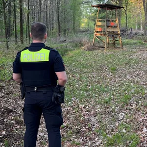 Ein Polizist steht vor dem Tatort in einem Wald bei Bückeburg.