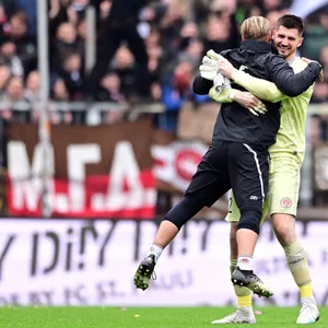 Torwarttrainer Marco Knoop in den Armen von Keeper Nikola Vasilj.