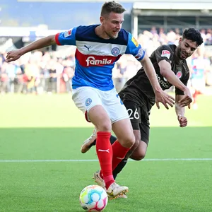 Hauke Wahl schirmt den Ball gegen Elias Saad ab.