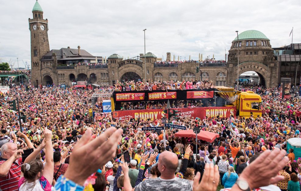 Schlagermovemasse umringen einen Partybus