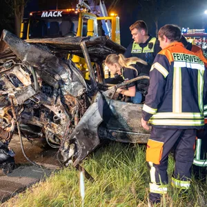 Polizei- und Feuerwehrkräfte begutachten das Wrack.