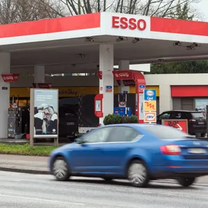 Eine Esso Tankstelle an der ein Auto vorbeifährt