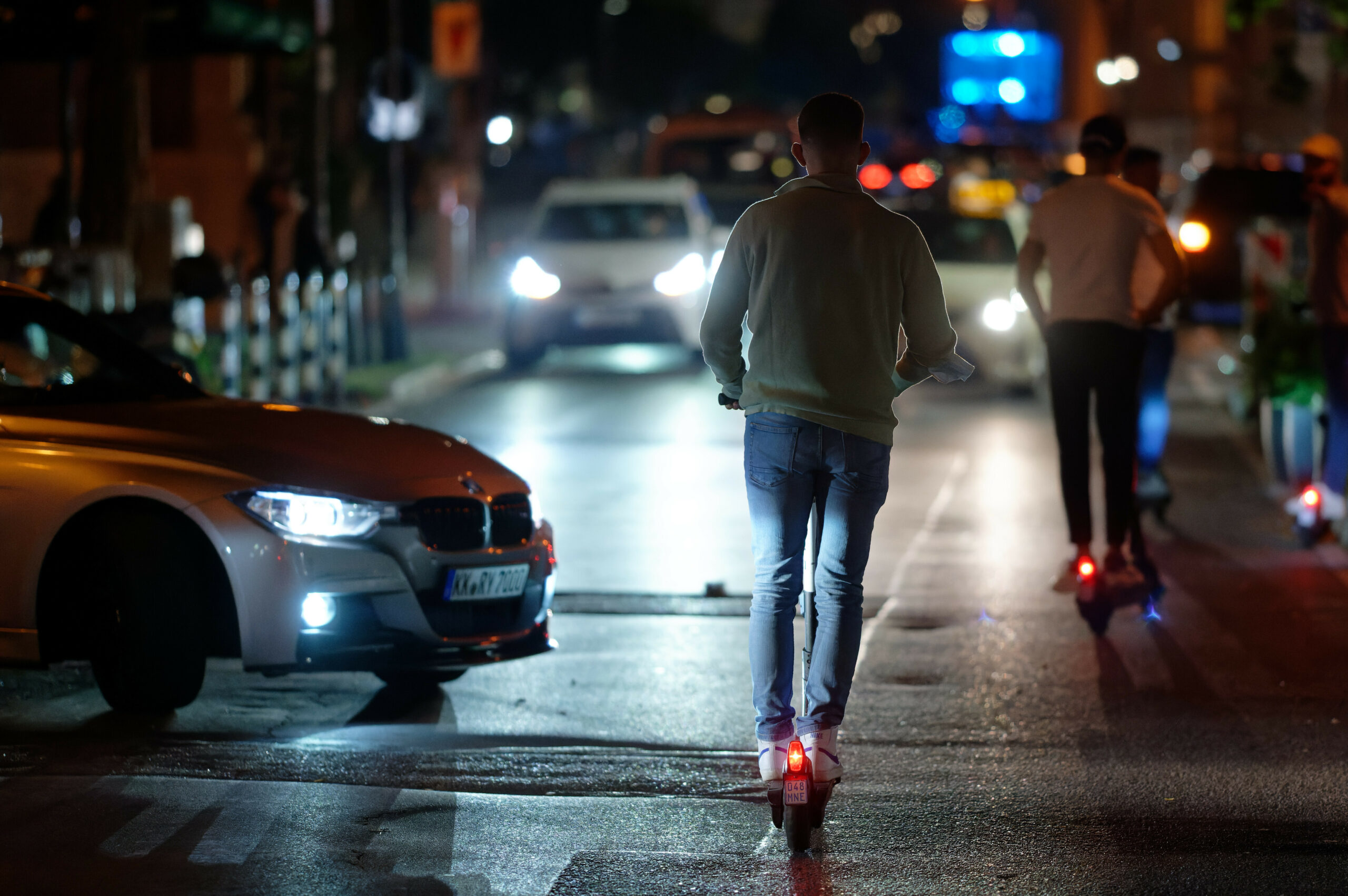 Ein Mann auf einem E-Scooter bei Nacht.