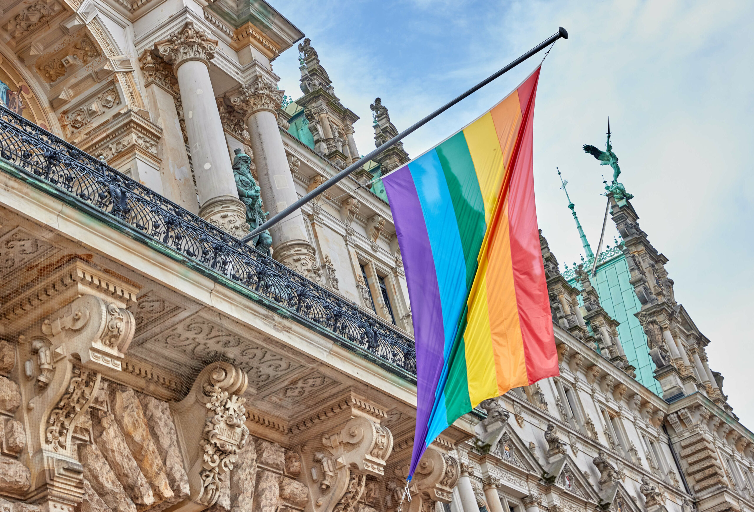 Eine Regenbogenflagge hängt am Eingang des Hamburger Rathauses.