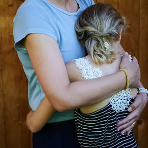 Ein Mädchen wird von seiner Mutter in den Arm genommen. (Symbolbild)
