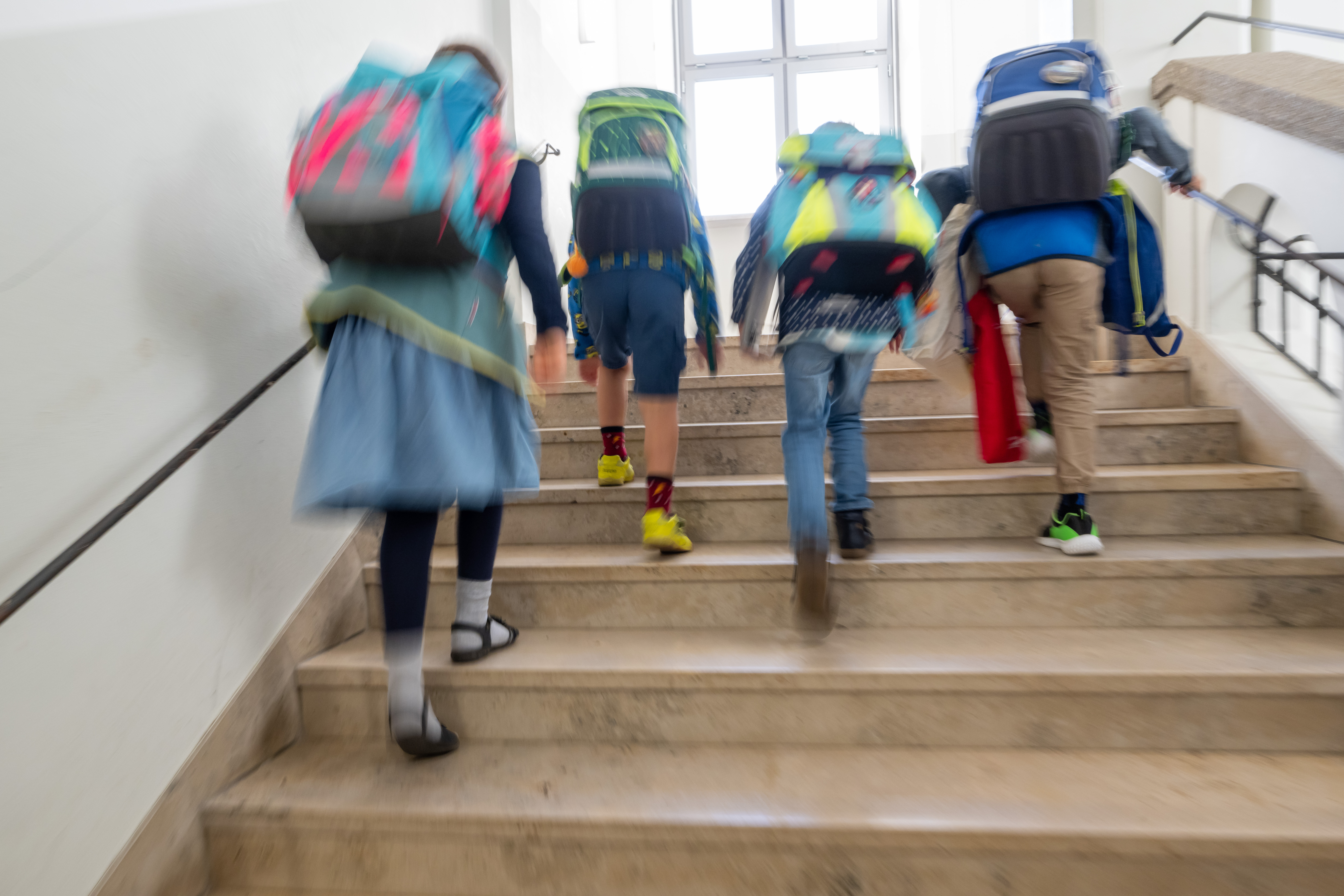 Schulkinder gehen eine Treppe hoch