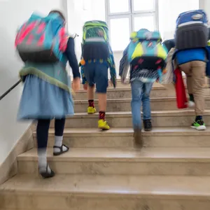 Schulkinder gehen eine Treppe hoch