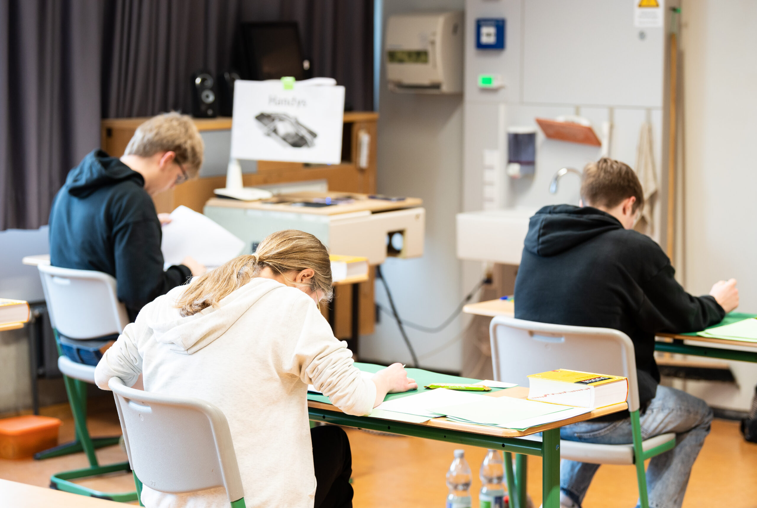 Schülerinnen und Schüler sitzen während einer schriftlichen Abiturprüfung im Klassenzimmer. (Symbolbild)