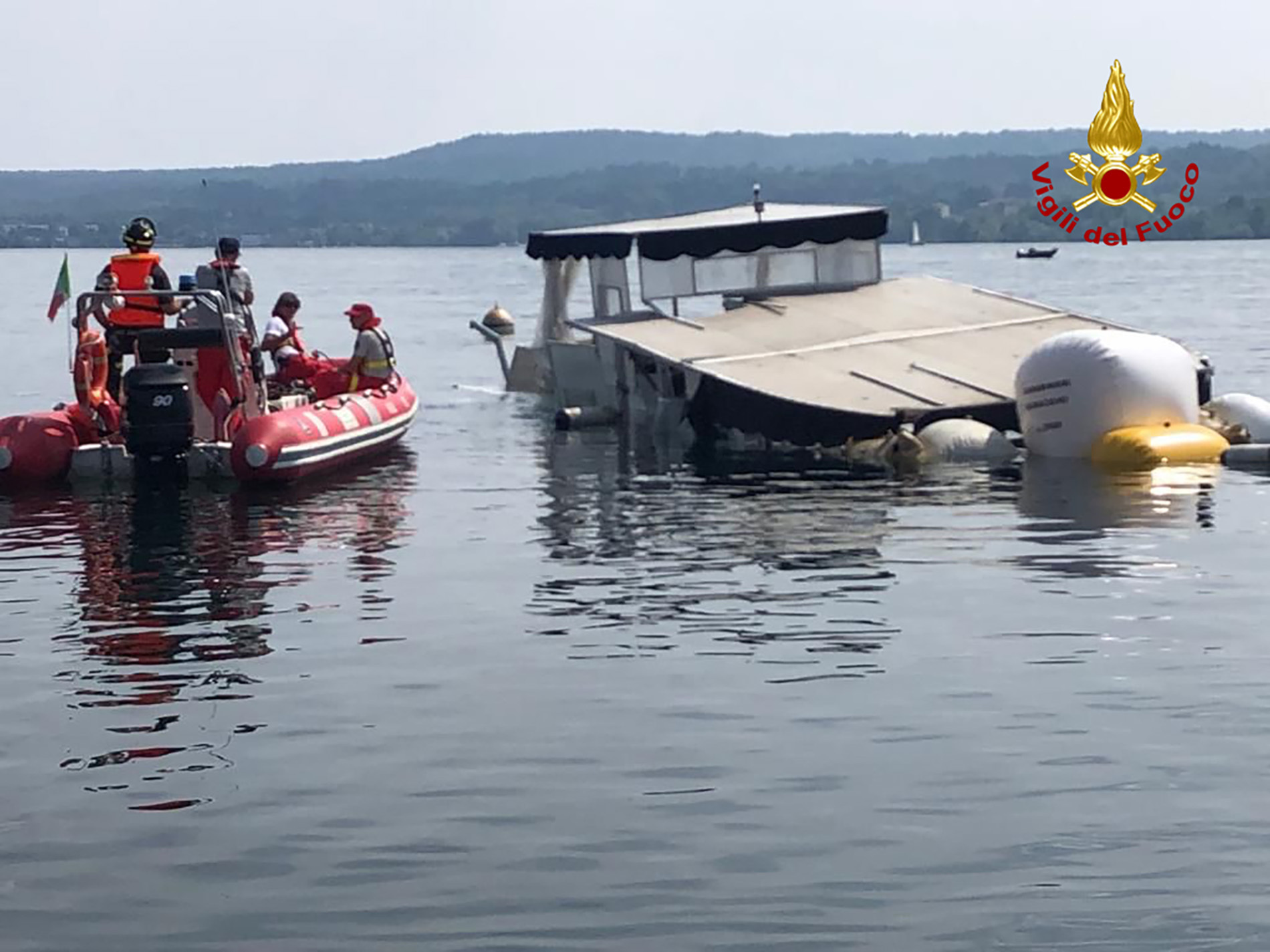 Einsatzkräfte der Feuerwehr holen das gesunkene Boot auf dem Lago Maggiore mit Ballons an die Oberfläche.