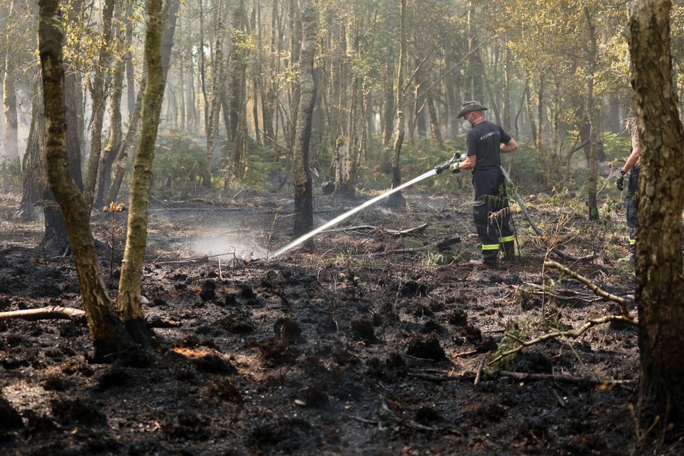 Ein Feuerwehrmann bei Löscharbeiten im Wald