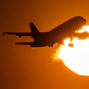 Eine Passagiermaschine hebt vor der untergehenden Sonne ab.