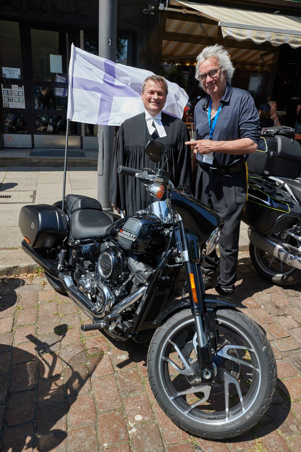 Pastor Lars Lemke (l), und Stefan Gwildis, Musiker und Schauspieler, stehen vor Beginn des Hamburger Motorradgottesdienst (Mogo) vor der Hauptkirche St. Michaelis.