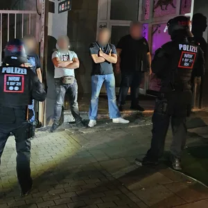 Polizisten stehen einer Reihe von Männern gegenüber.
