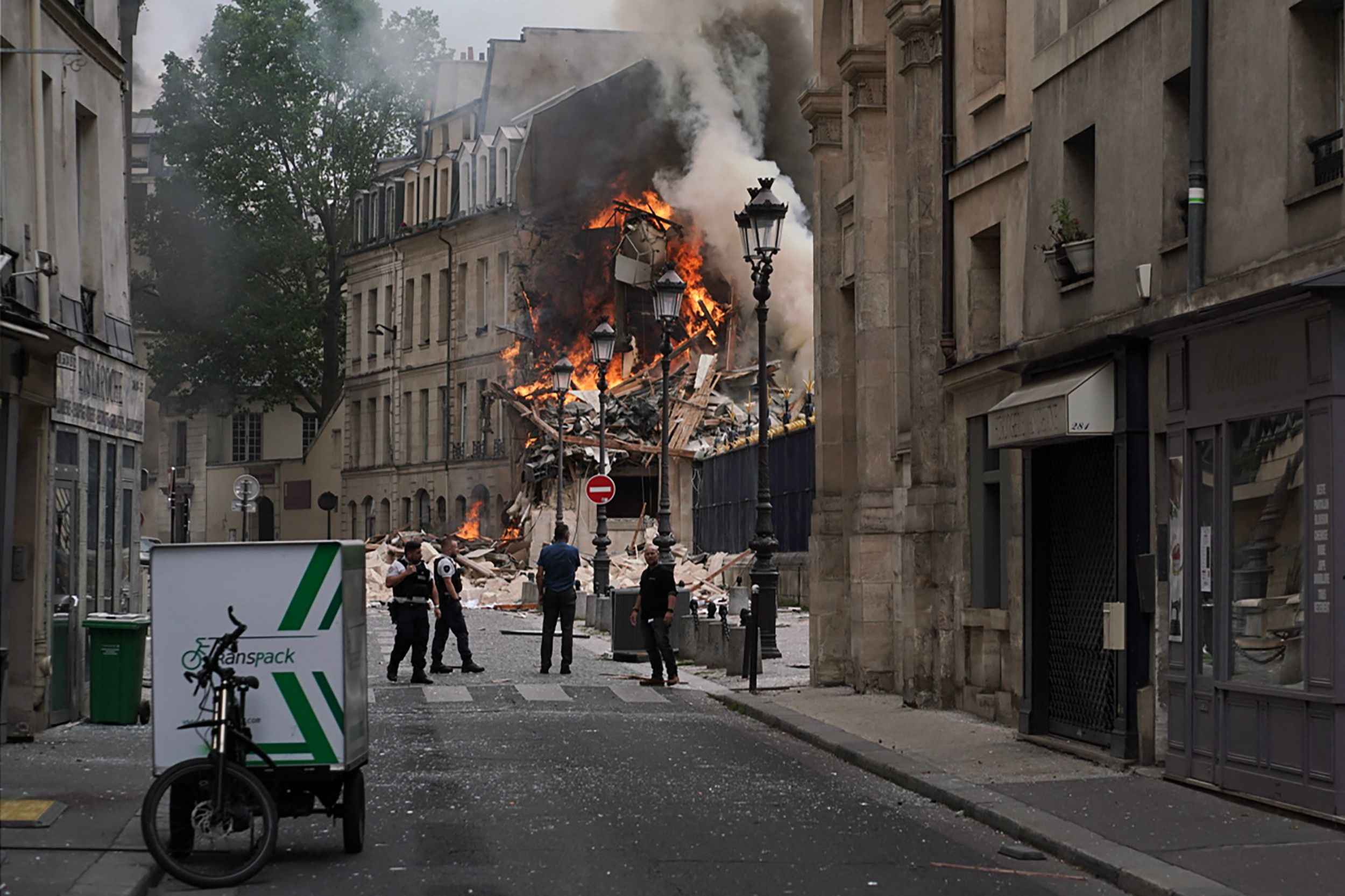 Rauchschwaden und Flammen steigen aus den Trümmern eines Gebäudes am Place Alphonse-Laveran auf.