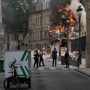 Rauchschwaden und Flammen steigen aus den Trümmern eines Gebäudes am Place Alphonse-Laveran auf.