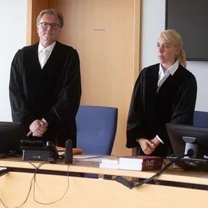 Martin Saal (2.v.l), Vorsitzender Richter, und Richard Uhle (r), Rechtsanwalt, stehen im Verhandlungssaal des Oberlandesgerichts Hamm.