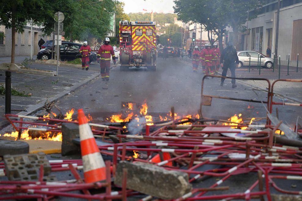 Feuerwehrleute treffen nach Ausschreitungen westlich von Paris ein, um Brände zu löschen. 