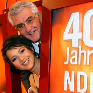 Madeleine Wehle und Denes Törzs blicken lachend hinter einen NDR-Schild hervor (Archivbild)