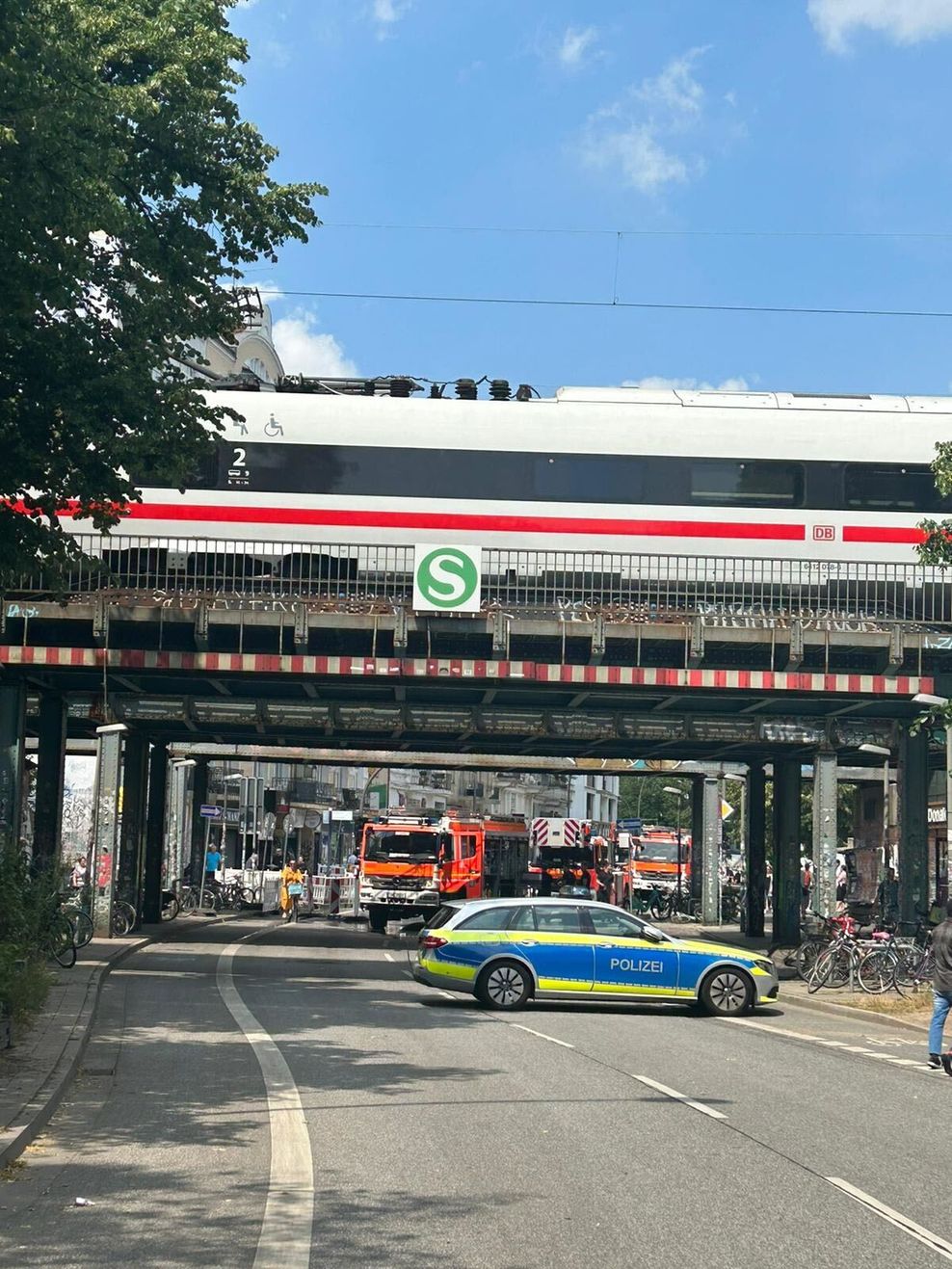 Aufnahme der Bahn-Brücke Sternschanze mit Einsatzfahrzeugen im Hintergrund.