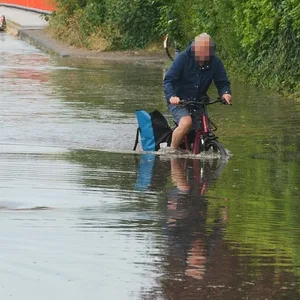 Einige Straßen in Bahrenfeld waren überschwemmt: Dieser Radfahrer kämpft sich durch das hohe Wasser.