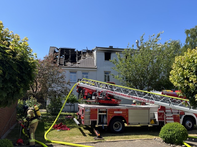 Ein Feuerwehrfahrzeug mit Drehleiter steht vor einem Wohnhaus in Steinkirchen im Alten Land, das am Dienstagmorgen in Teilen gebrannt hat.