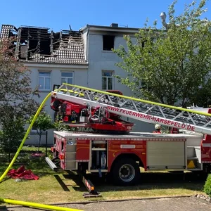 Ein Feuerwehrfahrzeug mit Drehleiter steht vor einem Wohnhaus in Steinkirchen im Alten Land, das am Dienstagmorgen in Teilen gebrannt hat.