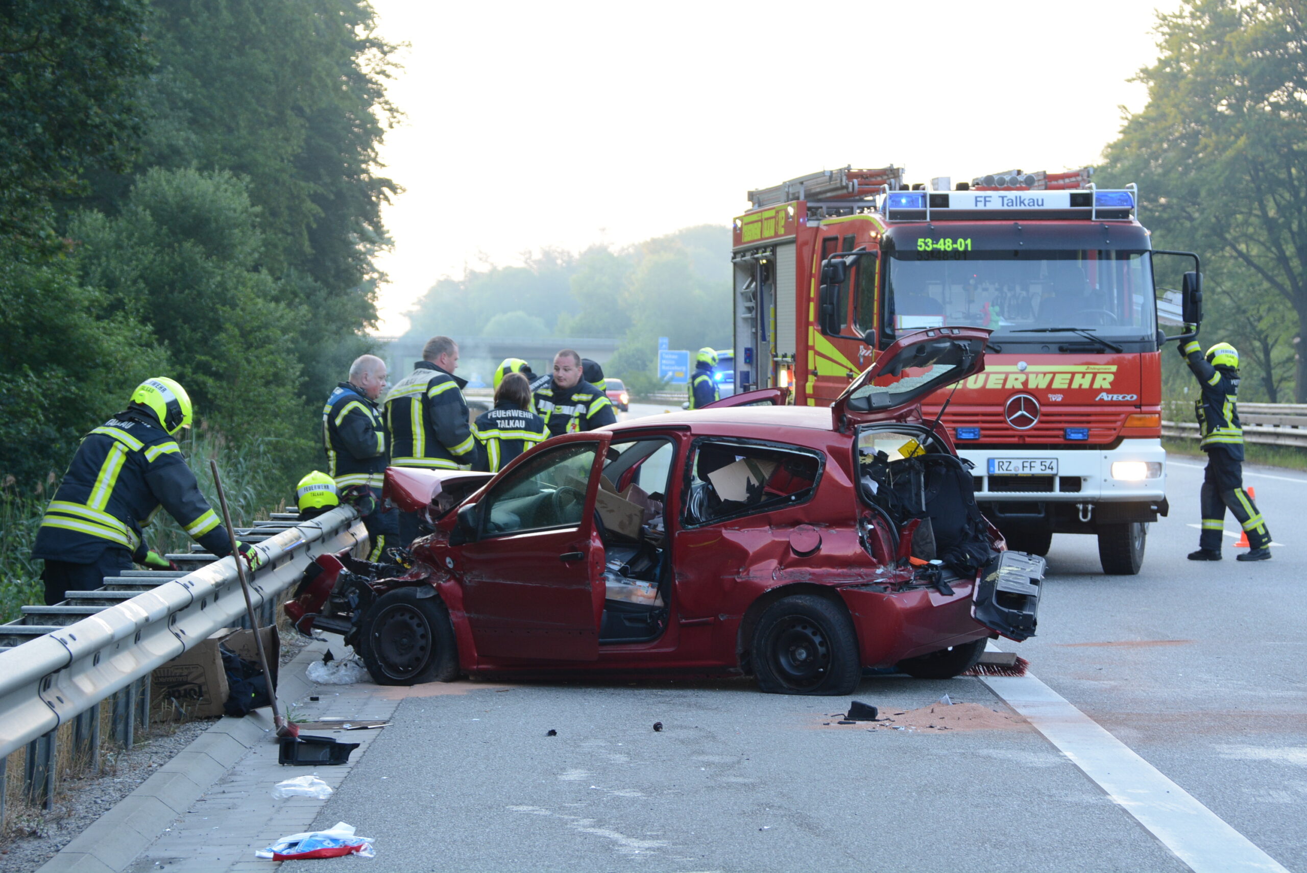 Feuerwehrkräfte vor dem zerstörten Kleinwagen.