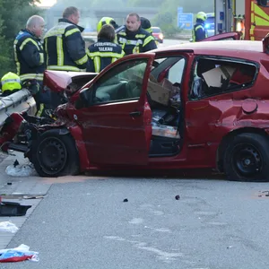Feuerwehrkräfte vor dem zerstörten Kleinwagen.