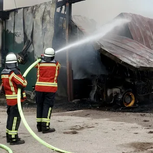 Feuerwehrleute löschen einen Scheunenbrand in Heinkenborstel