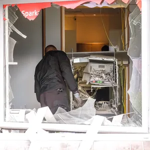 Ein Polizist begutachtet den gesprengten Geldautomaten.