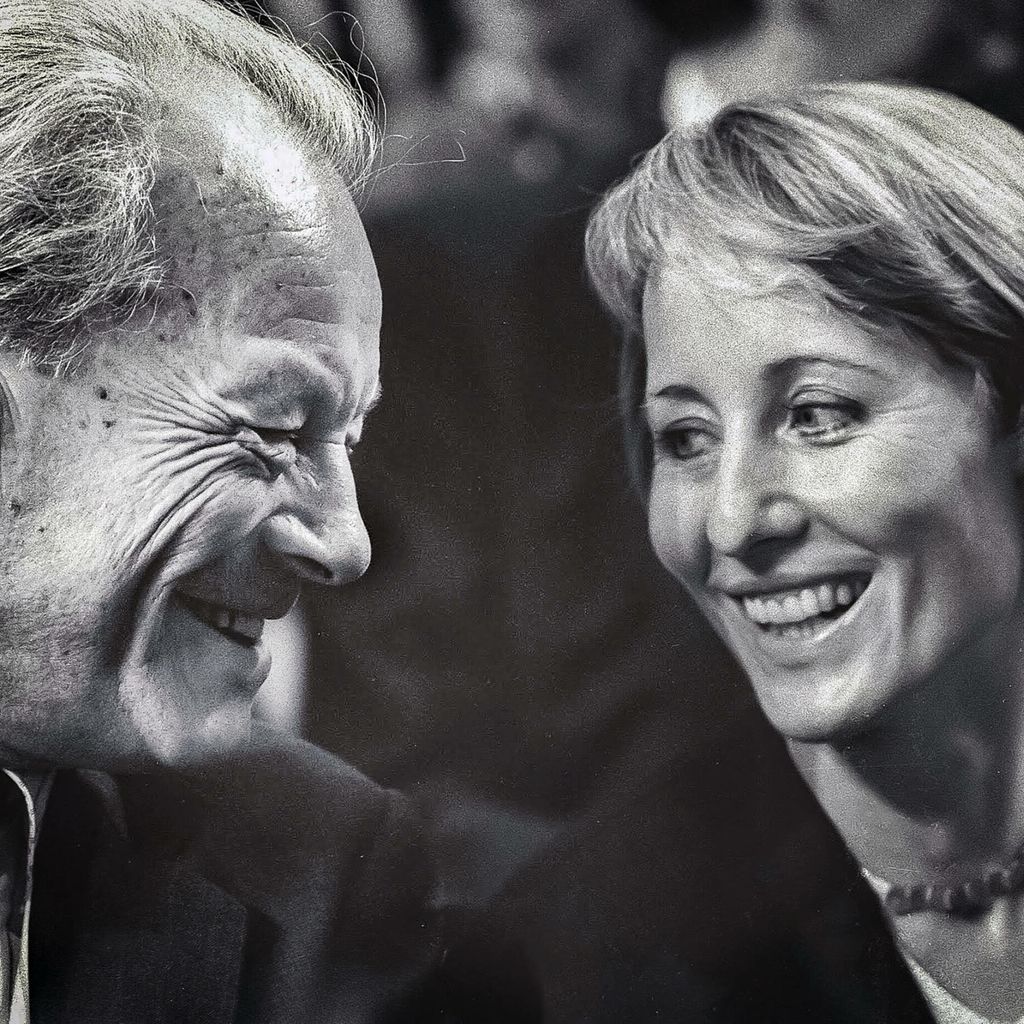 Willy Brandt und Brigitte Seebacher lächeln sich auf einem schwarzweiß-Foto an.