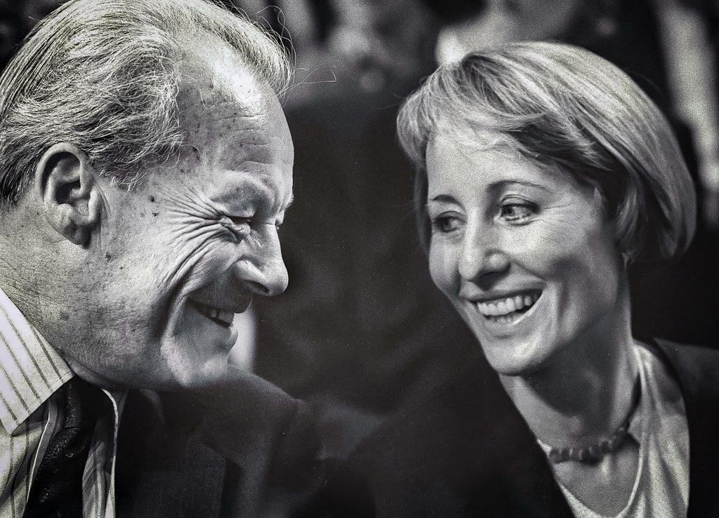 Willy Brandt und Brigitte Seebacher lächeln sich auf einem schwarzweiß-Foto an.