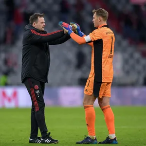 Toni Tapalovic klatscht sich mit Manuel Neuer ab.