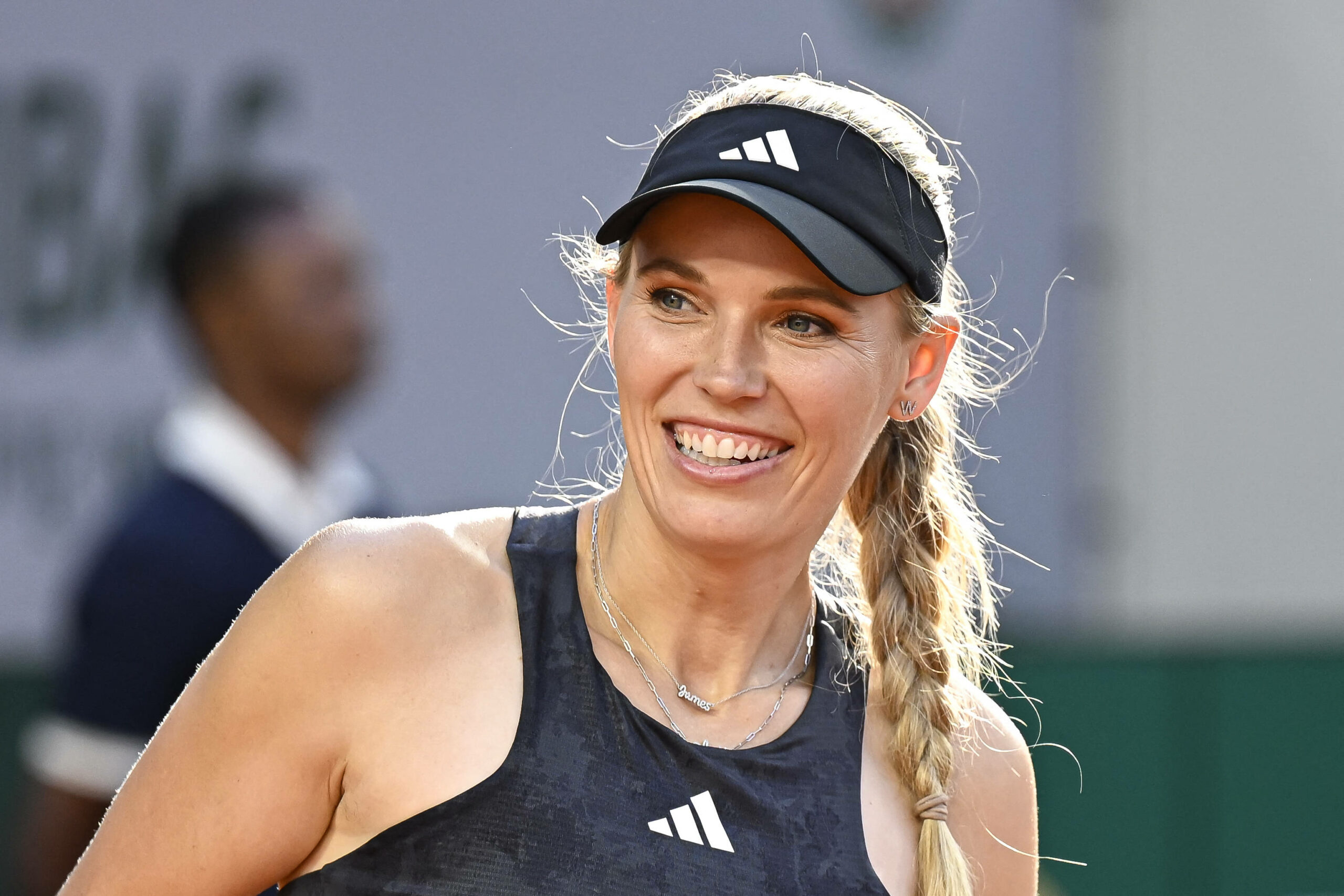 Caroline Wozniacki lächelt auf dem Tennis-Court.