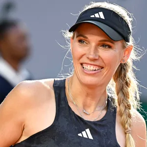 Caroline Wozniacki lächelt auf dem Tennis-Court.