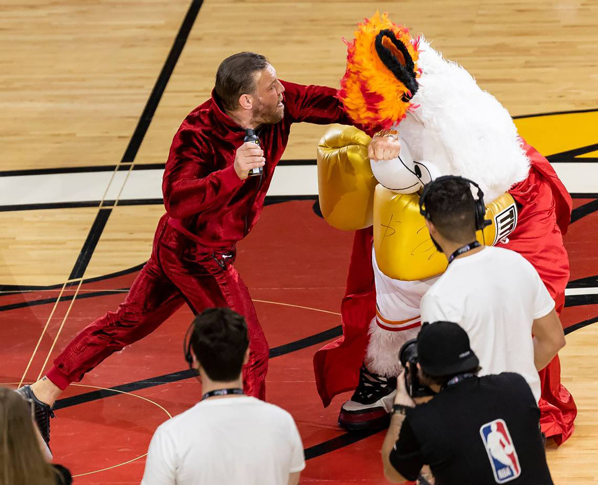 Connor McGregor schlägt auf das Maskottchen der Miami Heat ein.