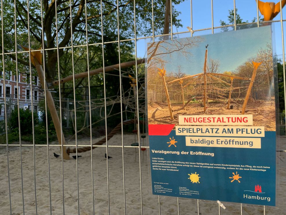 Ein Hinweisschild am Zaun weißt auf die Verzögerte Eröffnung des Spielgeräts hin