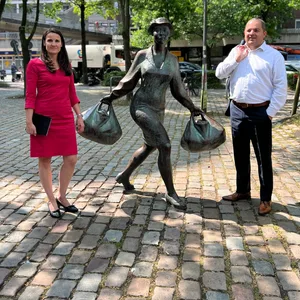 Pein und Neubauer stehen neben einer Statue auf dem kopfsteingepflasterten Platz.